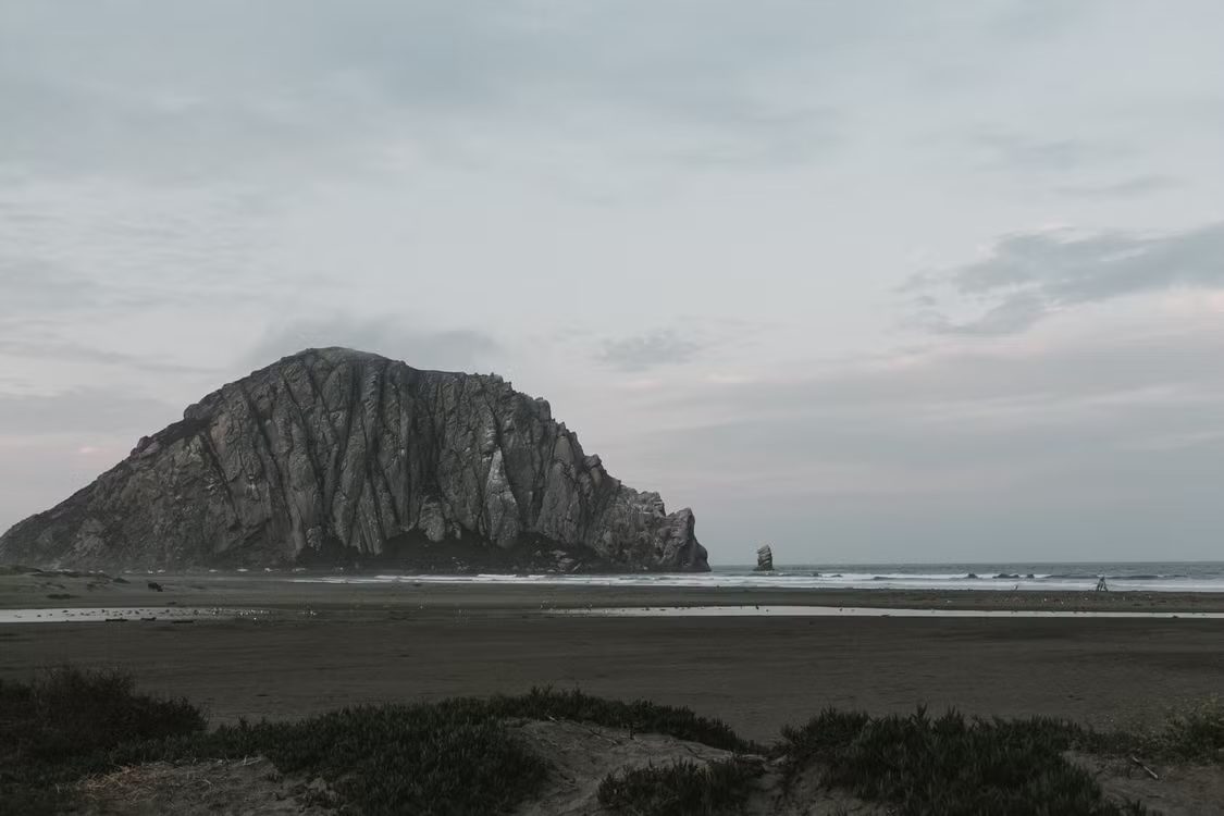 Morro Rock seen from Morro Strand State Beach on an overcast day